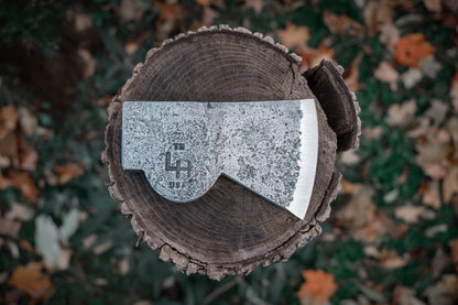 Axes with a branded axe head on a wooden block against a natural background